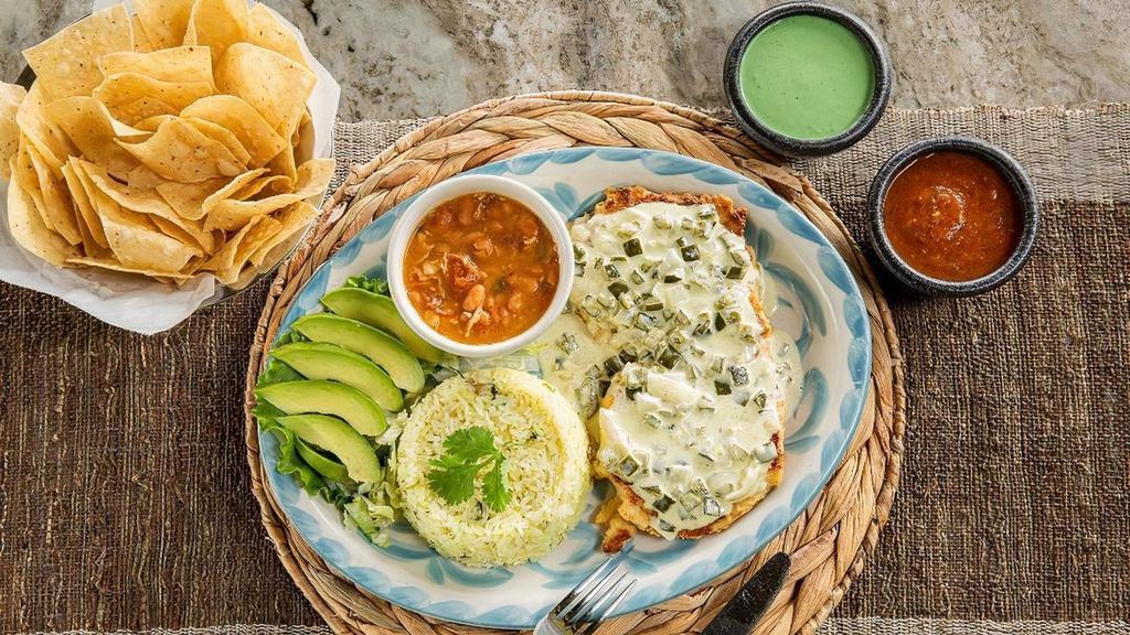 Tortilla Crusted Chicken · Chicken breast encrusted with corn tortilla chips that is grilled and covered in our poblano cream sauce. Served with avocado and your choice beans & rice. (Refried beans and Mexican rice Default)