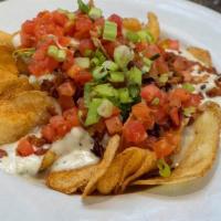 Blue Cheese Potato Chips · Topped with bacon, blue cheese, chopped tomatoes, and green onions.