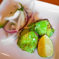 Hariyali Chicken Kebab · Chicken marinated with fresh green herbs served with grilled onion and salad.