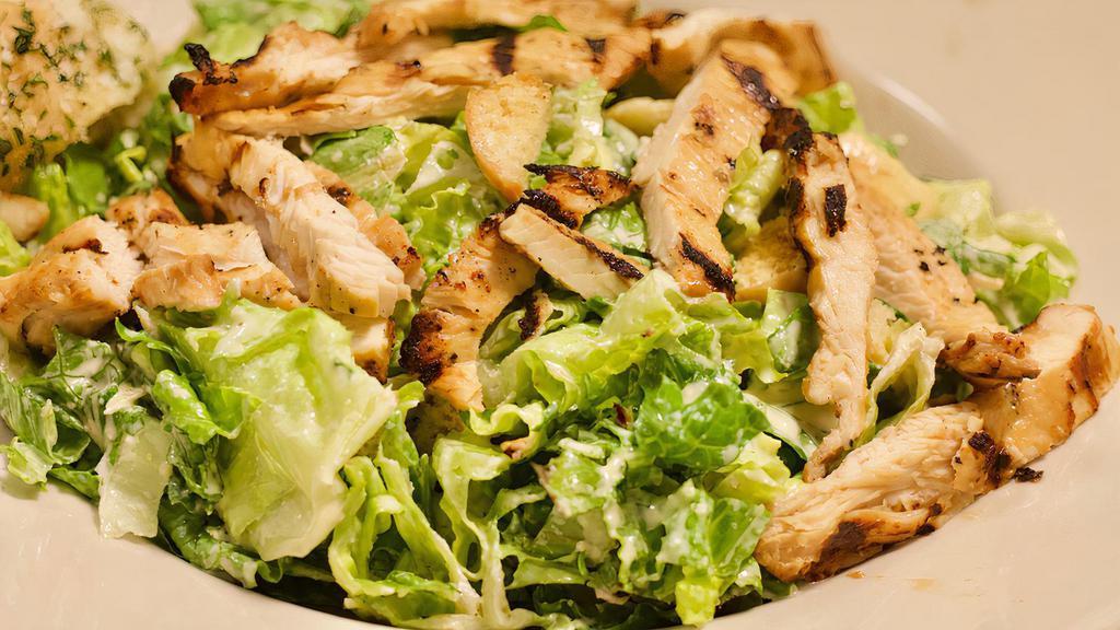 Chicken Caesar Salad · Crisp romaine lettuce tossed in our homemade caesar dressing with grilled chicken strips topped with garlic croutons.