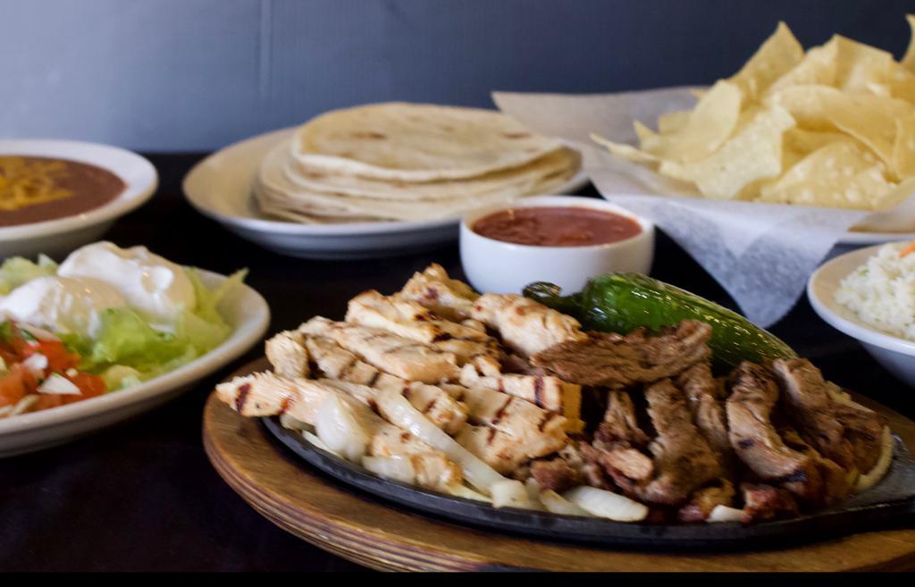 Fajitas Steak, Chicken Or Shrimp · Our fajitas are grilled just right, served over onions on a sizzling platter with rice, refried beans, pico de gallo, sour cream, and piping hot flour tortillas. Your choice of chicken or beef fajitas.