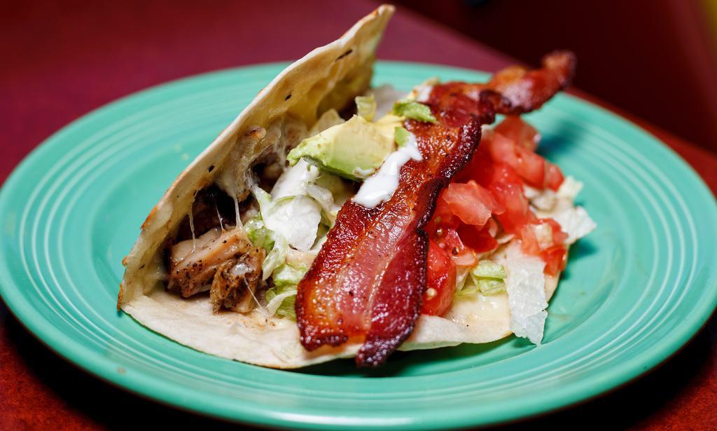 Chicken Ranch Taco · Grilled chicken fajitas, lettuce, ranch dressing, tomato, avocado, melted Monterey jack cheese and one strip of bacon on a toasted fresh flour tortilla.