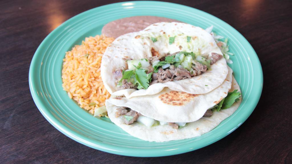 Asada Taco Plate · Two beef asada tacos served with onions or cilantro on the side topped with guacamole sauce. Served with homemade flour tortillas, refried beans, and rice or sub beans and rice for the side of vegetables (combo of mushrooms, tomatoes, onions, zucchini, and yellow squash).