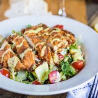 Crispy Chicken Club Salad · Greens tossed with bacon, egg, cheese, cucumber, and tomatoes topped with slices of buttermi...