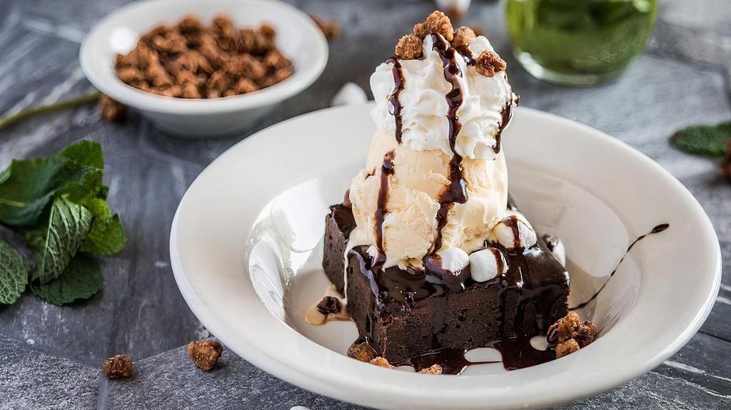 Crescent City Mud Sundae · Giant warm brownie topped with melted marshmallow, nuts, vanilla ice cream, and chocolate sauce.