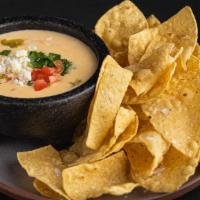 Chips & Queso · Vegan . Bold, creamy, with just the right amount of kick–our hatch green chili queso is topp...
