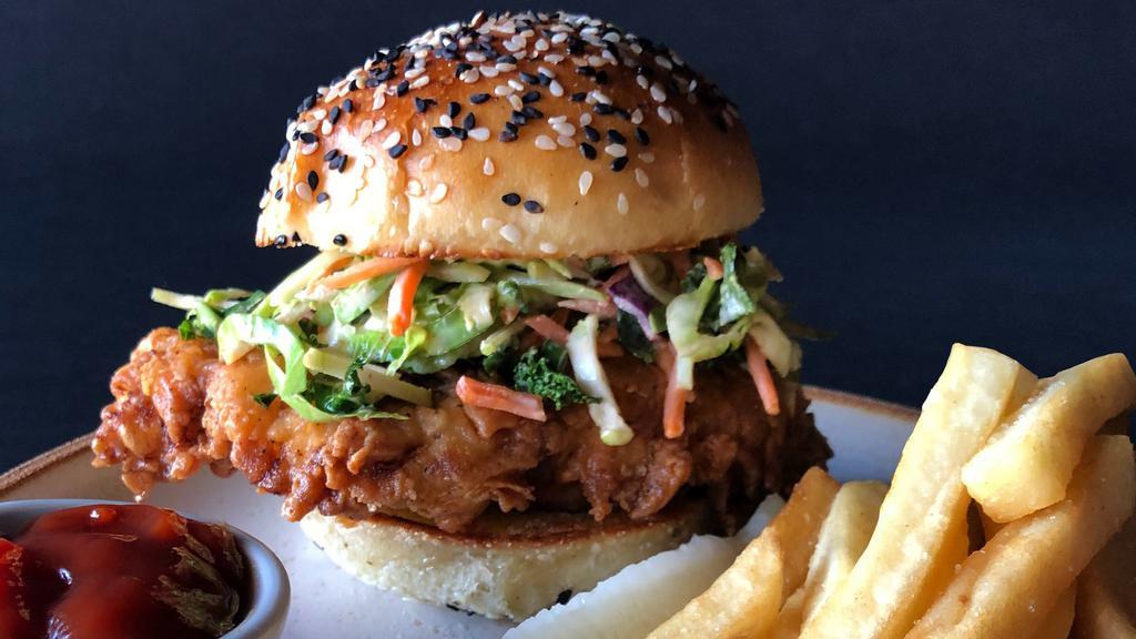 Fried Chicken Sandwich · A burst of savory and spicy flavor in every bite, with sriracha soy, Brussel sprout slaw, cabbage, scallions, and toasted seeded bun.