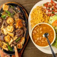 Fajitas Texanas · Texas fajitas, beef, chicken, shrimp, onions, bell peppers, tomato, rice, beans & salad
