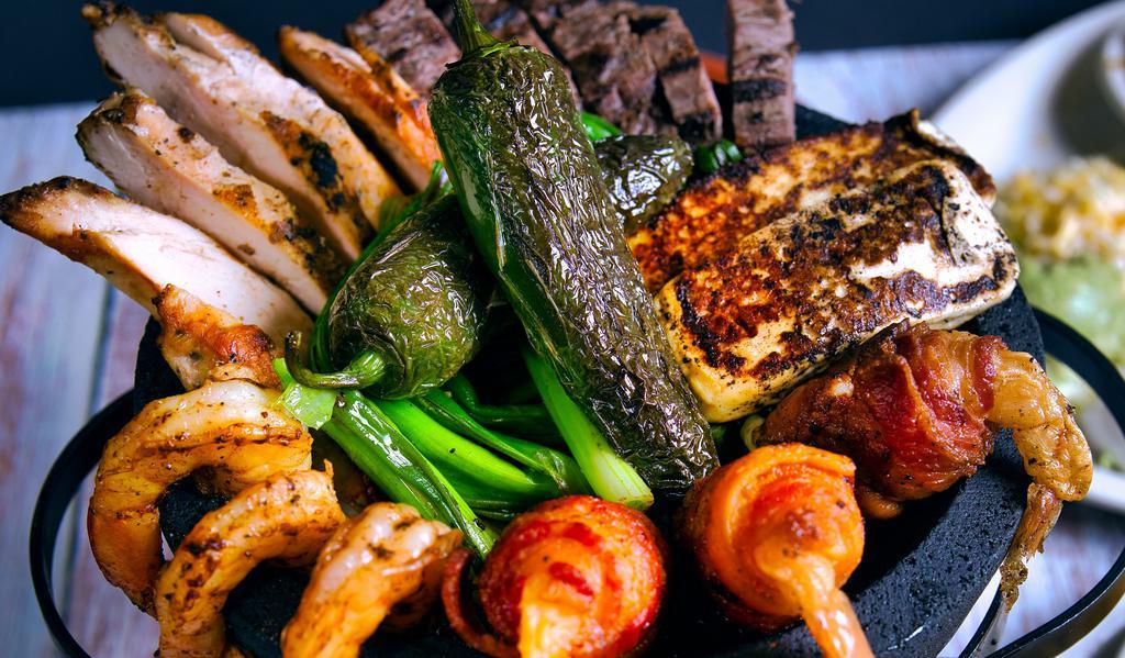 Molcajete For Two · Fajita beef, fajita chicken, shrimp brochette, grilled shrimp and grilled panela cheese with green onions, fresh jalapenos and adobo sauce. Served with housemade guacamole, sour cream, pico de gallo and flour tortillas, Mexican rice and refried beans.