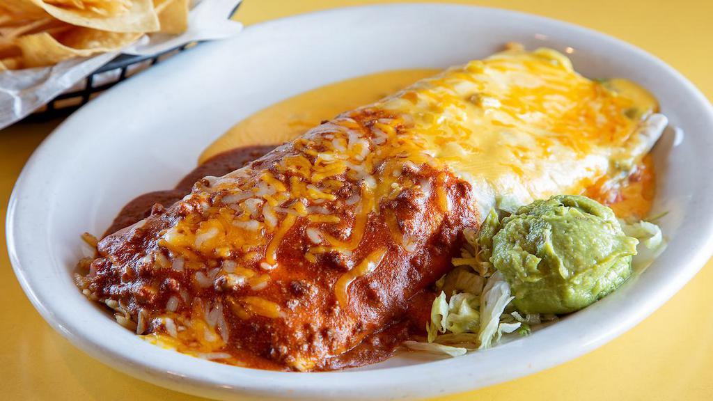 Texas Burrito · It’s a giant Texas-sized burrito filled with seasoned beef, refried beans, rice, lettuce, tomatoes, and cheese. Topped with chili con carne and chile con queso. Served with guacamole.