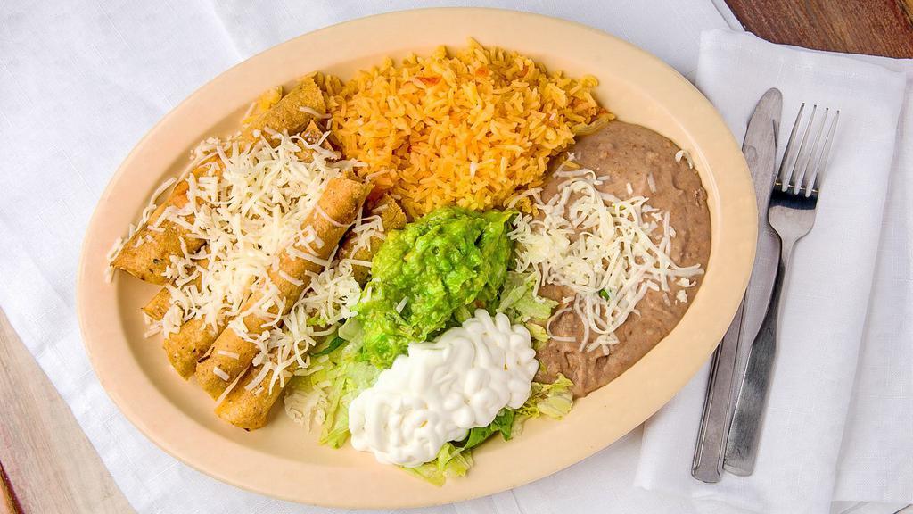 Flautas · Two flour tortillas filled with seasoned beef or fried and smothered with Chile con queso. Served with guacamole, rice, and refried beans.