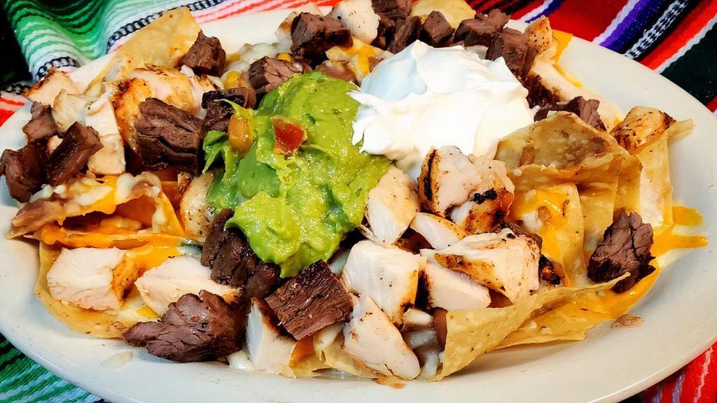 Nachos - Fajita · Homemade chips topped with refried beans, melted cheese and your choice of beef or chicken fajita.  Garnished with guacamole and sour cream.
