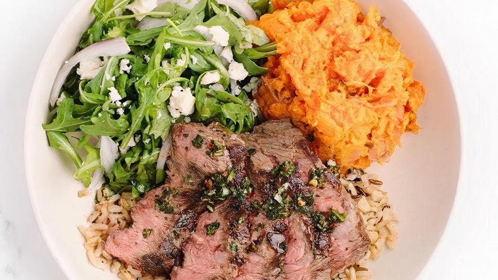 Grass Fed Steak · 100% grass fed steak, herb marinated over a bed of warm organic rice & quinoa, with chimichurri and two sides