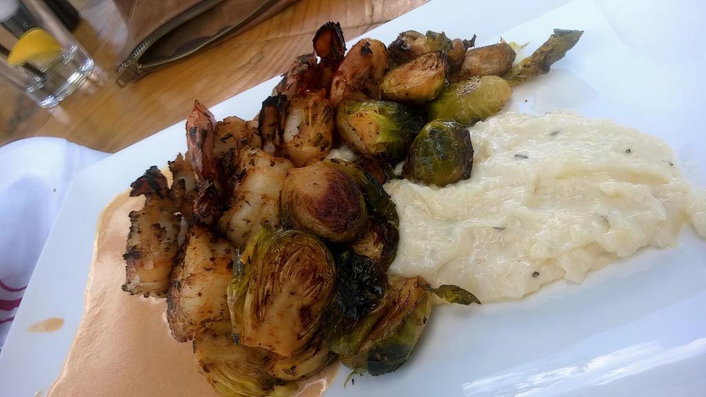 Redfin Shrimp & White Cheddar Grits · Creamy white cheddar grits topped with 6 jumbo gulf shrimp and sautéed kale and a smoked tomato beurre blanc.