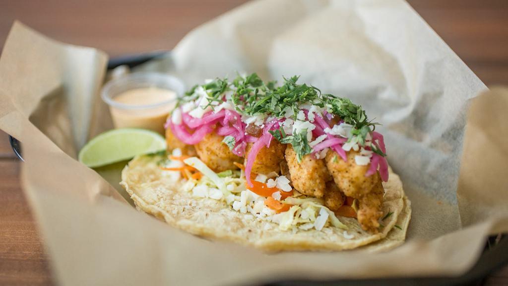 Baja Shrimp · Hand-battered fried shrimp with cooked cabbage slaw topped with pickled jalapenos, onions, cotija cheese, cilantro and a wedge of lime. Served with Chipotle sauce on your choice of tortilla. Dairy, Soy, Gluten, Eggs, Shellfish. *Flour tortillas contain Gluten.