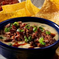 New! Brisket Queso · Our creamy, homemade green chile queso topped with smoked, shredded brisket, chopped green o...