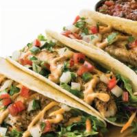 Grilled Fish Street Tacos · Three warm tortillas filled with fresh pico de gallo, homemade slaw, and zesty chipotle sauc...
