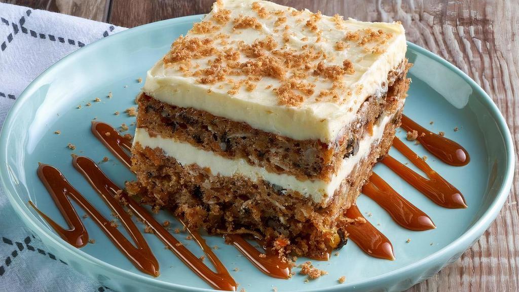 Carrot Cake · Sweet, lightly spiced cake with freshly-shredded carrots, sweet 'n juicy pineapple, flaky coconut and crunchy walnuts, covered with rich cream cheese icing, topped with cinnamon cookie crunch and drizzled with caramel sauce