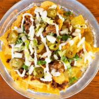 Chili Nachos · Warm Tortilla Chips covered with our House Made Chili, melted Cheddar Cheese, served with ja...