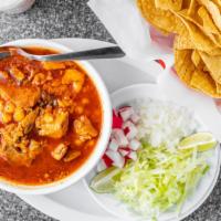 Pozole · Savory pork, hominy, and red chilis plus the added extras of shredded lettuce, diced onion, ...
