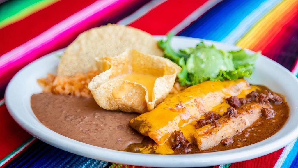 Spinach Enchiladas · Topped with Chihuahua cheese sauce and sour cream served with rice and black beans.