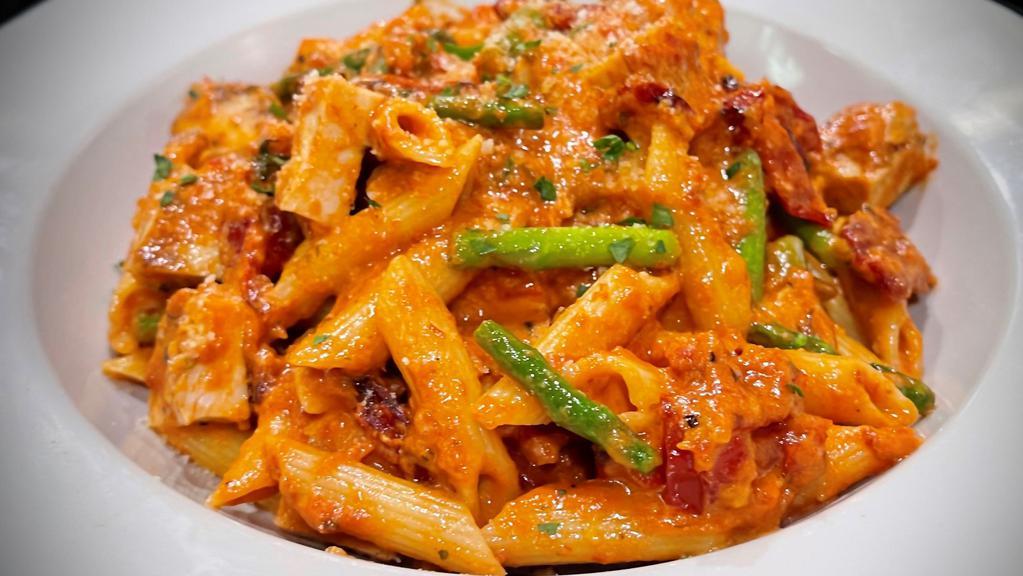 Penne Alla Vodka With Chicken · Penne pasta tossed with garlic, olive oil, sun-dried tomatoes, asparagus, tomatoes sauce with a touch of vodka and cream with grilled chicken.