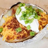 Baked Potato · Served with all toppings on the side (butter, cheese, sour cream, bacon and chives).