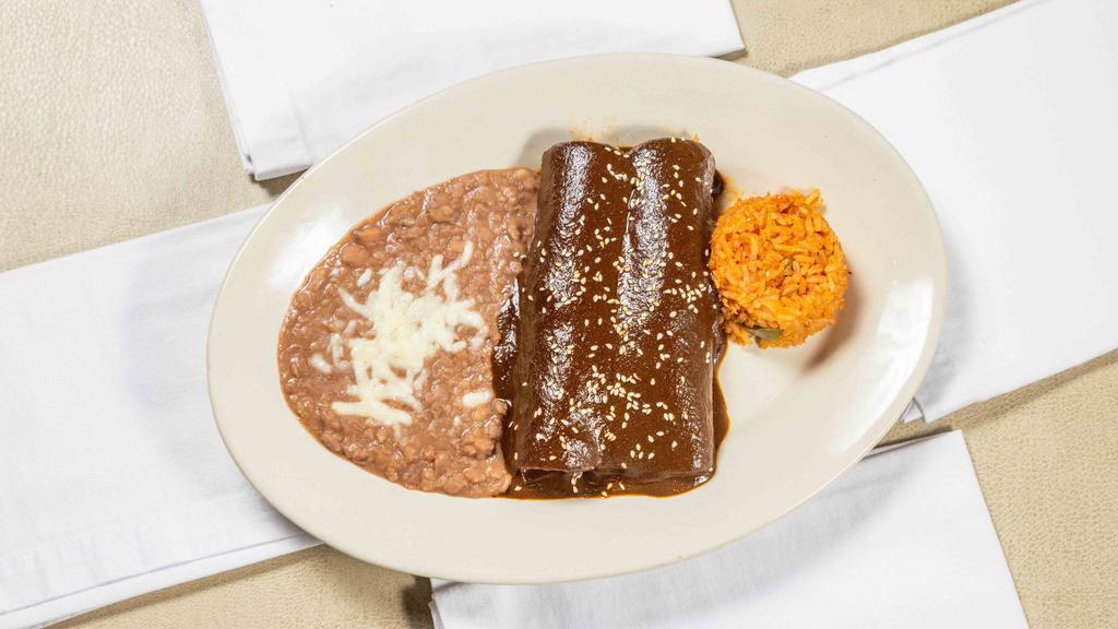 Enchilada De Mole · Two chicken enchiladas topped with traditional homemade mole. Served with rice and beans.