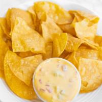 Queso And Chips · A bowl of our spicy chile con queso accompanied by our homemade tortilla chips.