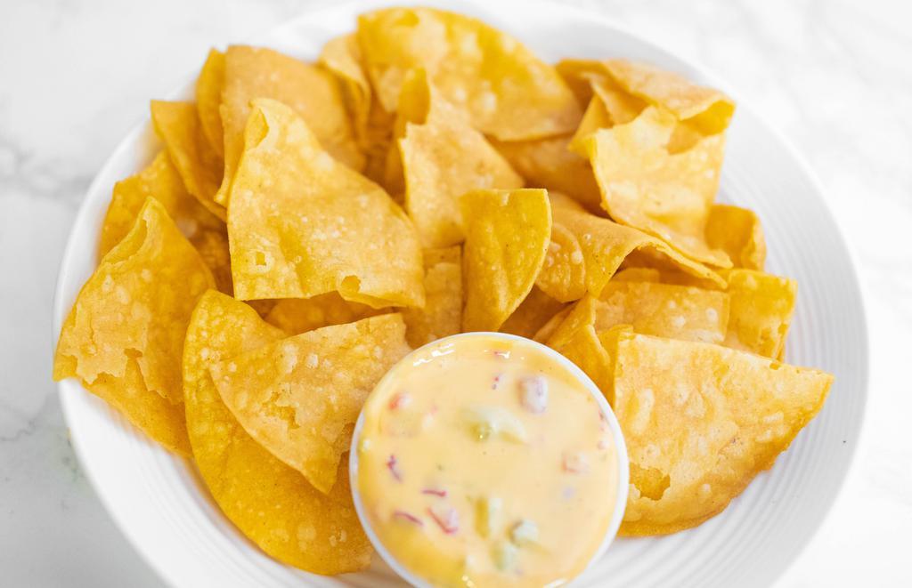 Queso And Chips · A bowl of our spicy chile con queso accompanied by our homemade tortilla chips.