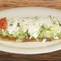 Huarache Sencillo · Big, oval-shaped, corn tortilla with beans, lettuce, sour cream, queso fresco, and tomato.