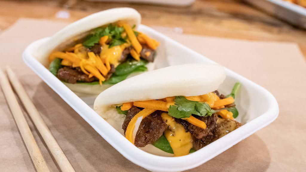 Steamed Buns · Mantou, a cloud-like pillow of steamed bread dough, ready to be filled with firecracker sauce, spinach, cilantro and your choice of protein.
