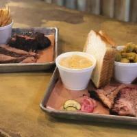 Two Meat Plate · Two choices of meat, two sides and one slice of bread and 1.5 ounce cup of sauce. Pickles an...