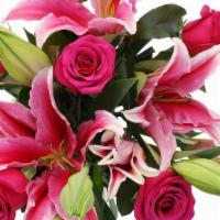 Debi Lilly Fragrant Rose Bouquet · Classic 6 red roses, two stems of lilies and greens wrapped in a kraft wrap.