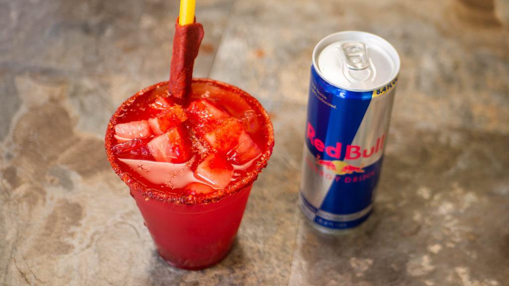 Red Bull Preparado · Red bull with the lime juice, chamoy and tajin topped with watermelon chunks.
