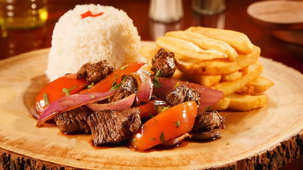Lomo Saltado · Filet Mignon, fresh tomatoes, onions sauteed and served with a side of fries and rice.
