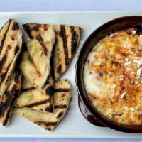 Chimayo Corn Dip · Warm creamy dip with grilled corn blended with ancho crema & cheese. Served with  grilled Me...