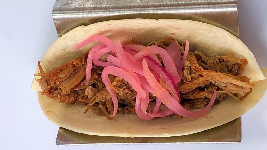 Bbq Pork Tacos · Two pulled smoked pork with a pineapple habanero BBQ sauce topped with pickled red onions. Served with coconut lime rice, smoky black beans & sweet corn cake