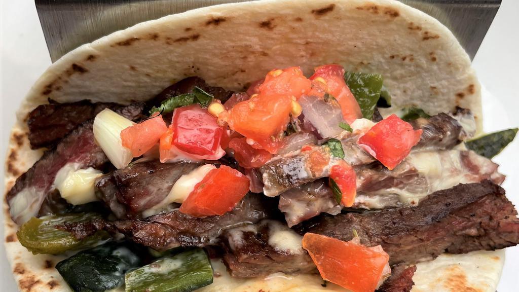 Steak Poblano Taco · Two Tacos - grilled skirt steak, roasted poblano, queso & pico. Served with coconut lime rice, smoky black beans and sweet corn cake.