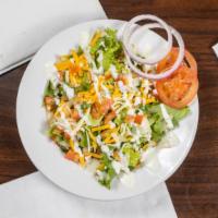 Garden Side Salad · A garden side salad with green leaf lettuce, Roma tomatoes, red onion, and Cheddar jack chee...