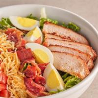 'Crib Cobb Salad · Smoked chicken over fresh greens, topped with corn, bacon, tomato, cheese, and boiled eggs.