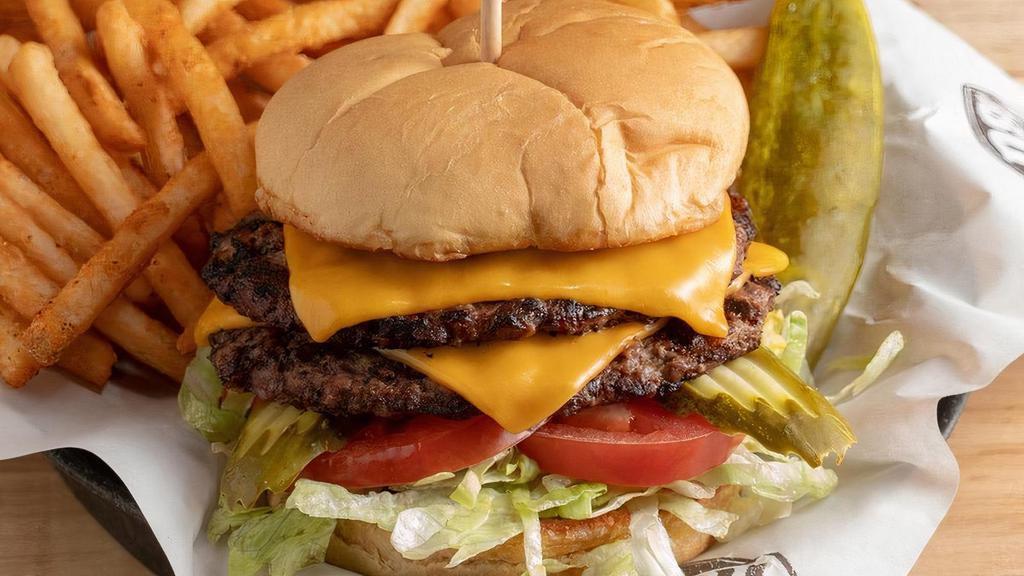 Classic Cheeseburger · Topped with cheddar, pickles, lettuce and tomato. Served with one side and a pickle.