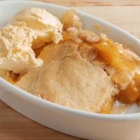 Peach Cobbler · Delicious golden peaches and melt-in-your-mouth pastry, served with ice cream.
