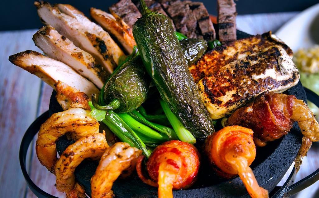 Molcajete For Two · Fajita beef, fajita chicken, shrimp brochette, grilled shrimp and grilled panela cheese with green onions, fresh jalapenos and adobo sauce. Served with housemade guacamole, sour cream, pico de gallo, mixed cheese and flour tortillas, Mexican rice and refried beans.
