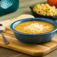 Southwest Chicken Soup · A bowl of delicious southwest broth with shredded chicken, pinto beans, and roasted corn gar...