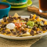Fajita Nachos · Tortilla chips topped with fajitas, refried beans and mixed cheeses. Served with sour cream,...