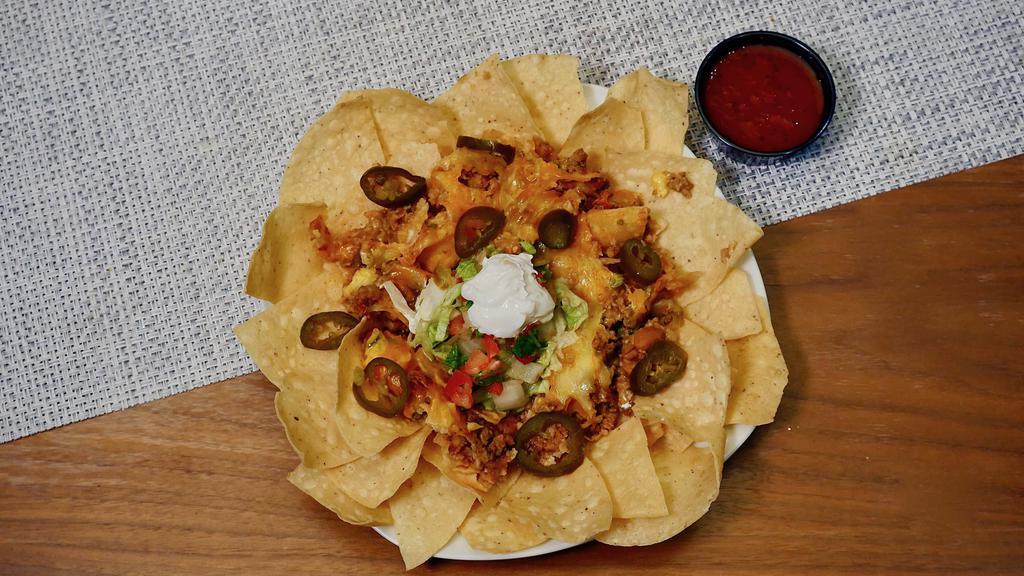 Nachos Ole · Seasoned beef or shredded chicken served on tortilla chips with chile con queso, refried beans and mixed cheeses. Served with sour cream, pico de gallo, guacamole and jalapeños.