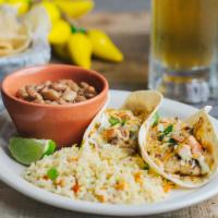 Fish Tacos · Two corn tortillas filled with blackened tilapia, shredded lettuce, and corn salsa drizzled ...