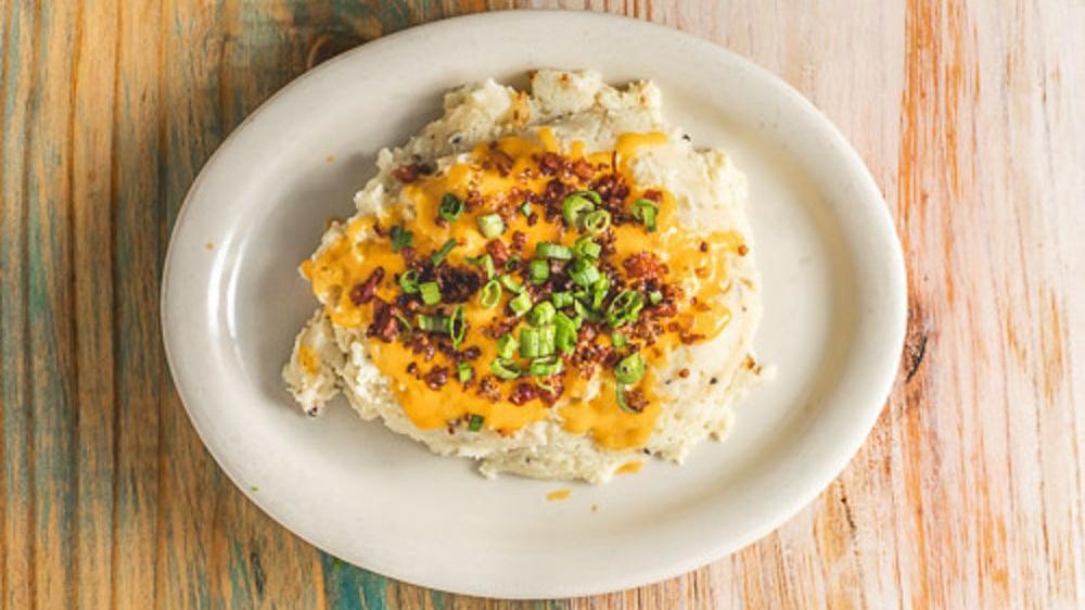 Loaded Mashed Potatoes · Creamy mashed potatoes with cheese, bacon bits, sour cream, and chives.