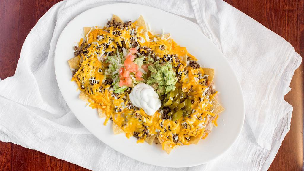 Nacho Plate · Consist of tortilla chips covered with melted cheese. (Chips, Beans, Choice of Meat, Mozzarella, Cheddar Cheese, Lettuce, Sour Cream, Guacamole, Jalapeños).